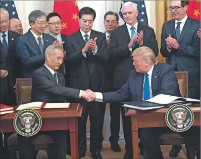  ?? (AFP) ?? US President Donald Trump, and China’s Vice Premier Liu He (left), the country’s top trade negotiator, shake hands as they sign trade agreements between the US and China during a ceremony in the East Room of the White House in Washington on Wednesday.