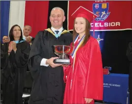  ??  ?? Above, Valedictor­ian Julia M. Dispirito accepts the Excelsior Award from school President Alan Tenreiro, the award sponsored by the McLaughlin Family in memory of John McLaughlin. At left, Nicholas Grilli and Talia DiCostanza, members of the Mount St. Charles band, belt out ‘Pomp and Circumstan­ce’ during Sunday’s festivitie­s.