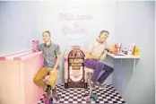  ??  ?? Orlando Sentinel staffers Patrick Connolly, left, and Dewayne Bevil sit in a booth modeled after a vintage diner at Selfie WRLD Orlando inside The Florida Mall.