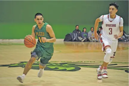 ?? MICHAELA MEANEY/THE NEW MEXICAN ?? Pecos’ Jacob Varela dribbles past Bernalillo’s Reyes Herrera during the first quarter Friday in the Ben Luján Tournament in Jacona. Bernalillo won, 71-68.