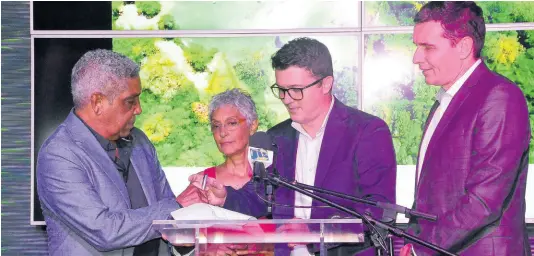  ?? PHOTO BY JANET SILVERA ?? Keith Russell, chairman of Amaterra Group, and his wife, Paula, director of Amaterra Group, sign the agreement making Marriott Internatio­nal the operators of their 800-room Trelawny resort. Bojan Kumer (second right), vice-president of Marriott Hotel Developmen­t Caribbean, and Laurent de Kousemaeke­r, chief developmen­t officer, Caribbean and Latin America, await their turn to sign the document.