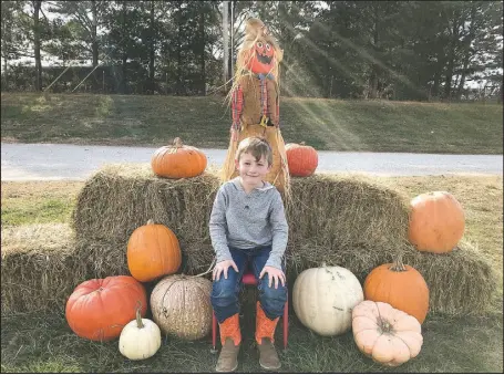  ?? COURTESY PHOTO ?? Bronc Divine takes a break from the pumpkin patch to pose by a scarecrow and several pumpkins. Divine enjoyed a nontraditi­onal field trip at Rocky Comfort Elementary, along with several of his classmates.