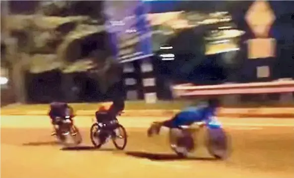  ??  ?? Dangerous stuff: Young cyclists performing the Superman stunt in the night at a housing area.