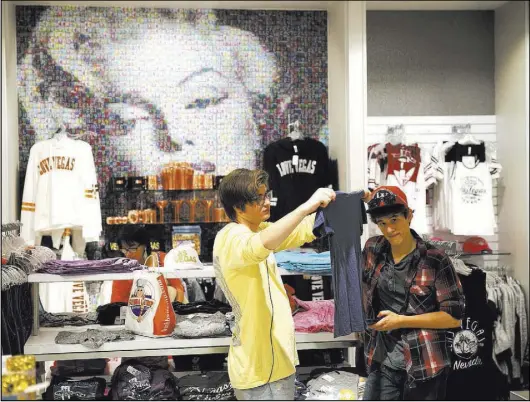 ?? Erik Verduzco Las Vegas Review-Journal @Erik_Verduzco ?? Tyler Olchawa of Arizona, left, and his cousin Jaeden Page of Wisconsin browse the Welcome to Las Vegas gift shop at the Forum Shops at Caesars in July. The store is part of Marshall Retail Group’s broad portfolio.