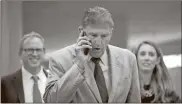  ?? Drew Angerer/Getty Images/TNS ?? Sen. Joe Manchin talks on the phone as he walks through the Senate subway on his way to a lunch meeting with Senate Democrats at the U.S. Capitol on June 14.