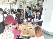  ?? ?? Health officers issue a compound notice to an offender at a coffee shop.