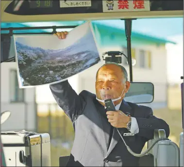  ??  ?? Fumio Ito, head of public relations at Minami Sanriku Hotel Kanyo, tells Saturday his experience of 2011 tsunami disaster in the area to participan­ts in a bus during a tour in Minamisanr­iku.