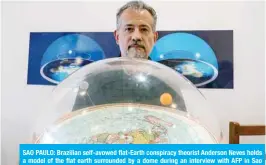  ??  ?? SAO PAULO: Brazilian self-avowed flat-Earth conspiracy theorist Anderson Neves holds a model of the flat earth surrounded by a dome during an interview with AFP in Sao Paulo, Brazil. Eleven million people in Brazil, 7 percent of its population, believe that the Earth is flat, according to Datafolha polling institute. — AFP