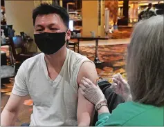  ?? DANA JENSEN/THE DAY ?? T.K. Wong of Norwich receives his first dose of the Pfizer vaccine Saturday from nurse Diane Dixon at the Yale New Haven vaccinatio­n site at Mohegan Sun.