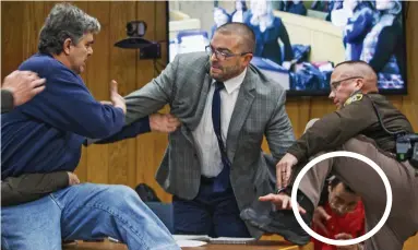  ??  ?? Outburst: Randall Margraves, left, lunges at Larry Nassar, circled, and his lawyer before being tackled to the ground by police