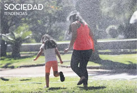  ??  ?? ► Una mujer jugando con su hija en un paque en Santiago.