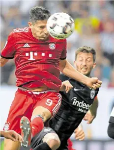  ?? DPA-BILD: DEDERT ?? Robert Lewandowsk­i (links, gegen David Abraham) köpft in dieser Szene das 2:0 für die Münchner.