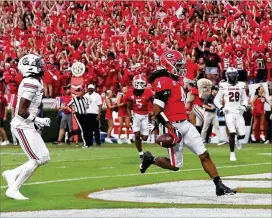  ?? CURTIS COMPTON/CURTIS.COMPTON@AJC.COM ?? James Cook scores after breaking through South Carolina defenders during the first quarter at Sanford Stadium on Saturday. Georgia ran for 184 yards on 31 carries, an average of 5.9 yards per attempt.