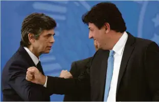  ?? Pedro Ladeira - 17.abr.20/folhapress ?? Luiz Henrique Mandetta (dir.) usa cotovelo para cumpriment­ar seu então sucessor Nelson Teich, durante a posse no Ministério da Saúde