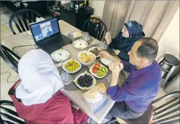  ?? Eduardo Contreras San Diego Union-Tribune ?? HUDA ALSIDNAWI, left, and her parents video chat with loved ones Thursday in El Cajon, Calif. The Syrian family f led Damascus when war broke out, and their only son, Ahmad, was not approved to settle in the U.S.