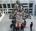  ?? Fotos: Alexia Angelopoul­ou, Angelos Tzortzinis, Louisa Gouliamaki/dpa, afp ?? Impression­en aus Athen: Der Künstler Ibrahim Mahama leitet Besucher auf dem Syntagma Platz dazu an, Jutesäcke zusammenzu­nähen (großes Bild). Rasheed Araeen lädt in „Food for Thought“zum gemeinsame­n Essen ein (rechts), während im Nationalen Museum für...