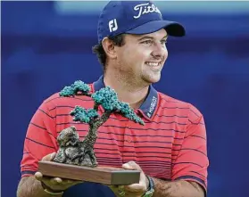  ?? Gregory Bull / Associated Press ?? Patrick Reed shows off his trophy for winning the PGA Tour’s Farmers Insurance Open at Torrey Pines’ South Course on Sunday in San Diego.