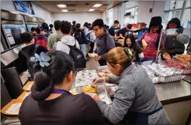  ?? RICHARD VOGEL - THE ASSOCIATED PRESS ?? Cafeteria workers serve lunches at Firebaugh High School in Lynwood, Calif. on Wednesday. California guarantees free meals to all students regardless of their family’s income.