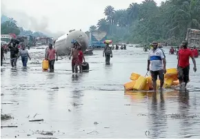  ?? AP ?? People wade through flooded roads in Bayelsa, Nigeria, during flooding which has hit much of the Sahel region.