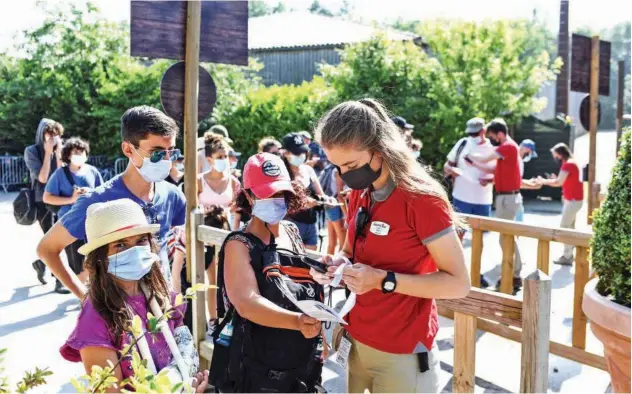  ?? Agence France-presse ?? ↑
An employee checks a visitor’s health pass at the entrance of the Puy du Fou theme park in Les Epesses, western France, on Wednesday.