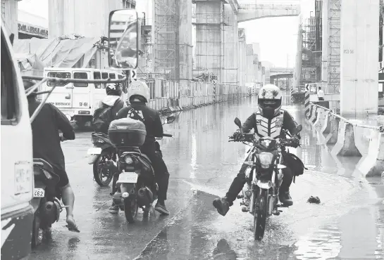  ?? (PNA) ?? A MOTORCYCLE rider could not wait for the flood to subside along Araneta Ave. in Quezon City due to heavy rains from the southwest monsoon on Friday, Aug. 3.