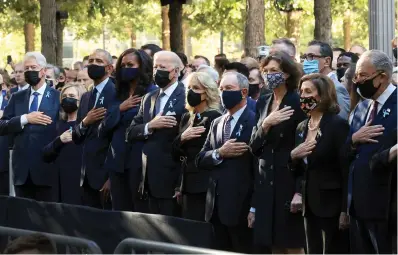  ?? Chip Somodevill­a/pool Photo via AP ?? ■ From left, former President Bill Clinton, former First Lady Hillary Clinton, former President Barack Obama, Michelle Obama, President Joe Biden, first lady Jill Biden, former New York City Mayor Michael Bloomberg, Bloomberg’s partner Diana Taylor, Speaker of the House Nancy Pelosi, D-calif., and Senate Majority Leader Charles Schumer, D-N.Y., stand for the national anthem during the annual 9/11 Commemorat­ion Ceremony at the National 9/11 Memorial and Museum on Saturday in New York.