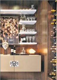  ?? PETER RYMWID/DINEEN ARCHITECTU­RE + DESIGN VIA AP ?? In this Kips Bay Decorator’s Showhouse project from 2013, Dineen Architectu­re + Design added big art to a tiny walnut wood panelled bar room.