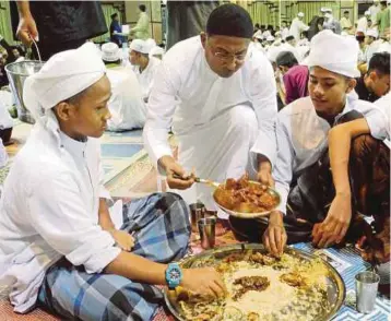  ?? PIC BY AHMAD A. TALIB ?? Perak Menteri Besar Datuk Seri Dr Zambry
Abdul Kadir serving food to guests during his weekly Thursday night ‘kenduri’ at his residence in Ipoh.