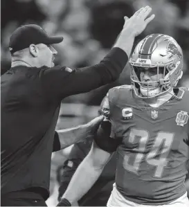  ?? JUNFU HAN / USA TODAY NETWORK ?? Lions coach Dan Campbell talks to linebacker Alex Anzalone during warmups before the NFC divisional playoff game between the Lions and Buccaneers at Ford Field on Sunday, Jan. 21, 2024.