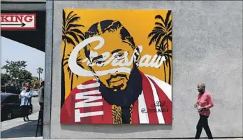  ?? Luis Sinco Los Angeles Times ?? ARTIST DEMI LAUREN painted an image of Hussle on the wall of Earle’s Restaurant in Leimert Park.