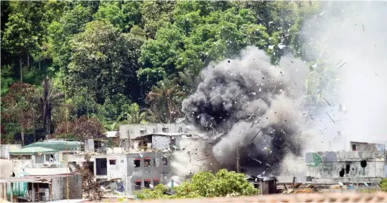  ??  ?? Debris and smoke are seen after an OV-10 Bronco aircraft released a bomb during an airstrike, as government forces continue their assault against insurgents from the Maute group. (Reuters)