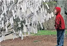  ??  ?? IN A 2007 photo, Lucas Pritchard of Rochester, New York reads some of the wishes left by visitors on the Hirshhorn’s wish tree. | BILL O’LEARY Washington Post