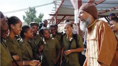  ??  ?? COMMUNITY FOUNDER Ben Ammi Ben Israel enjoys a laugh with the first group of IDF inductees from the Dimona Village of Peace.