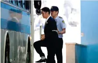  ?? — Bloomberg ?? Jay Y. Lee is escorted by a prison officer as he boards a bus at the Seoul Central District Court on Friday.