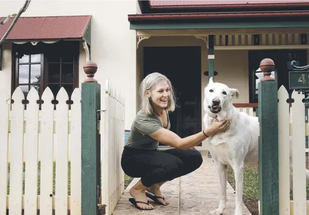  ??  ?? WORTH IT: Natalie Fichera with Kimba the dog at her Forest Gardens home is a Gen Y first-home buyer at age 23.