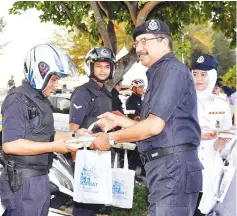  ??  ?? Ramli handing out breaking of fast package to police personnel at the event yesterday.