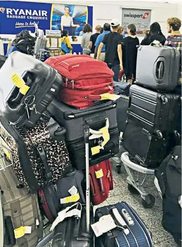  ??  ?? Ryanair passengers were told to retrieve their luggage after the low-cost airline cancelled 14 flights from Stansted airport yesterday