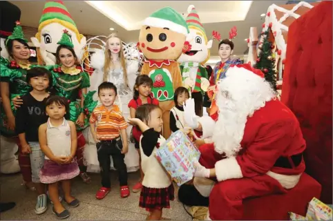  ?? GUSLAN GUMILANG/JAWA POS ?? MOMEN BAHAGIA: Pengunjung cilik Pakuwon Mall berkesempa­tan bertemu dengan Sinterklas dan mendapat hadiah Natal kemarin (24/12).