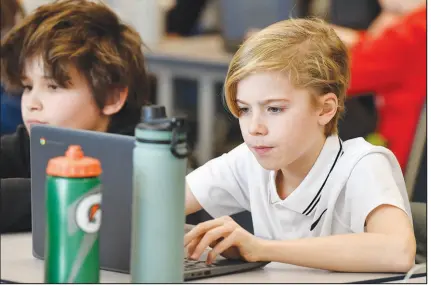  ?? ?? Caleb Roberts, right, and his classmates attempt to “Find the Bot” in Piercey’s class. The students each summarized a text about boxing champion and Kentucky icon Muhammad Ali then tried to figure out which summaries were penned by classmates and which was written by the chatbot.