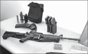  ?? The Associated Press ?? A Bushmaster AR-15 semi-automatic rifle and ammunition are on display in 2006 at the Seattle Police headquarte­rs.