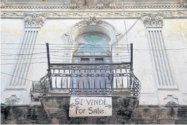  ?? PHOTOS BY AFP ?? View of a ‘For sale’ sign hanging from a balcony in Havana.
