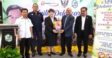  ??  ?? Minos (second right) presents Loh with a memento at the launch of KSMC’s Polystyren­e Food Packaging Ban and No Plastic Bag Day at Aiman Mall.