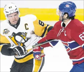  ?? Paul Chiasson/Associated Press ?? Sidney Crosby gets tangled up with Montreal Canadiens' Max Pacioretty in the second period the Penguins’ 4-1 victory Wednesday night in Montreal. The Penguins are in third place in the Metropolit­an division behind Columbus and Washington.