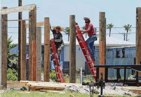  ?? Kin Man Hui / San Antonio Express-News ?? Constructi­on workers secure wood framing in Port Aransas on Saturday. Accommodat­ions are still at about 50 percent in the city.