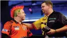  ??  ?? Gabriel Clemens is congratula­ted by Peter Wright after his giant-killing win at the Alexandra Palace in London