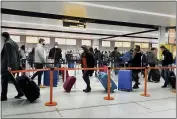  ?? GARETH FULLER — PA ?? On Dec. 20, passengers line up for check-in at Gatwick Airport in West Sussex, England, south of London.