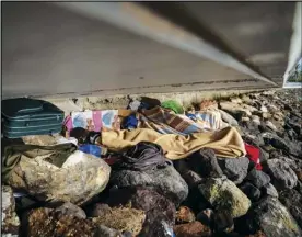  ?? ASSOCIATED PRESS ?? Khalid, a migrant from Gambia, sleeps on a breakwater under a bridge in Gran Canaria island, Spain, on Aug. 22.