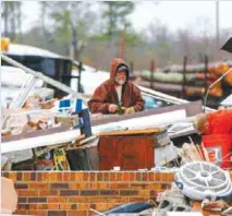  ?? — AP ?? ROSALIE, Alabama: In this Nov. 30, 2016, photo, Gregg Jefferey, left, and his son Tyler help a family friend clean up their business at Rosalie Plaza after a possible tornado ripped through the town.