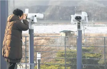  ??  ?? A woman looks through binoculars during a visit to the Imjingak peace park near the Demilitari­zed Zone (DMZ) dividing the two Koreas in the border city of Paju. — AFP photo