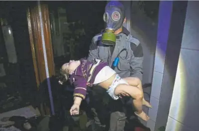  ?? Syrian Civil Defense White Helmets ?? An image released early Sunday by the Syrian Civil Defense White Helmets shows a rescue worker carrying a child after an alleged chemical weapons attack in the rebel-held town of Douma.